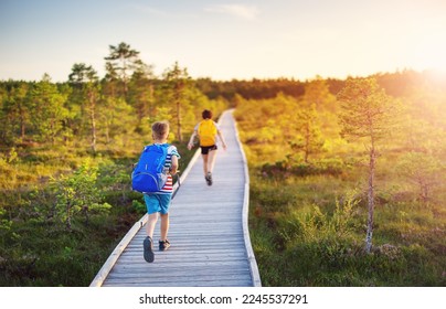 Children running on the boardwalk on bog. Concept of hiking, vacation and friendship. - Powered by Shutterstock