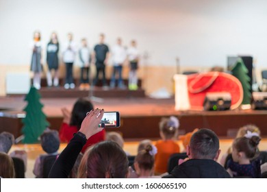 Children At School Perform On Stage In Front Of Parents. Young Talents On Stage. Blurry