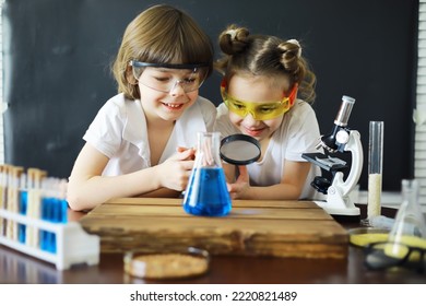 Children scientists. Schoolchildren in laboratory conduct experiments. Boy and girl experiments with a microscope. - Powered by Shutterstock