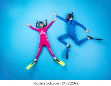 Children scuba diving deep in the sea. Studio shot on a blue background. - Powered by Shutterstock