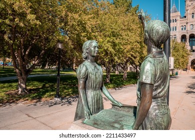 Children sculpture at entrance of Salt Lake City and County Building. Bronze artistic statues against trees. Beautiful creativity at famous landmark during sunny day.