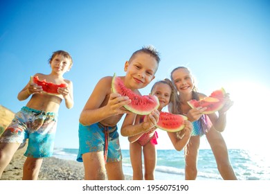 Children at sea. A group of children are eating a watermelon. High quality photo. - Powered by Shutterstock