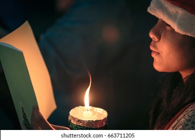 A Children Singer Of Caroler Hands Holding Candle And Book With Singing Carol Song On Celebration Of Christmas Day Background