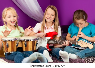 Children Ã¢Â?Â? sisters - making music; they are practicing playing guitar, bongo and flute - Powered by Shutterstock
