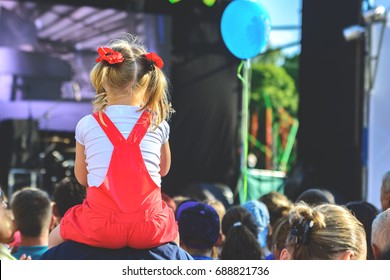 Children Sit Around The Neck At A Street Concert