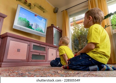 Children Sit In Front Of A Tv And Watch A Children's Show On.