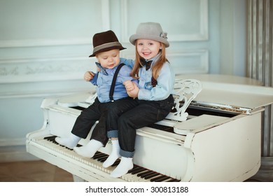 Children sit on a white piano