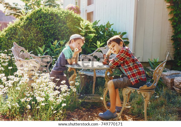 Kinder Sitzen Im Garten Am Tisch Stockfoto Jetzt Bearbeiten 749770171