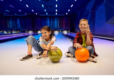 Children Sitting On The Lane In Bowling Alley