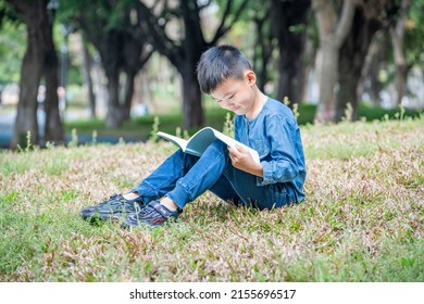Children sitting on the park grass reading