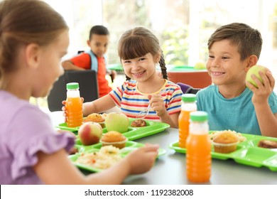 Children Sitting At Table And Eating Healthy Food During Break At School