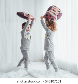 Children in soft warm pajamas playing in bed