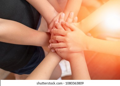 Children Students Hands Stacking Together For Harmonious Concept. Group Of Kids Cohere In Unity. School Kids Hands Volunteer For Public Services And Successful Community Sustainability Goal Concept