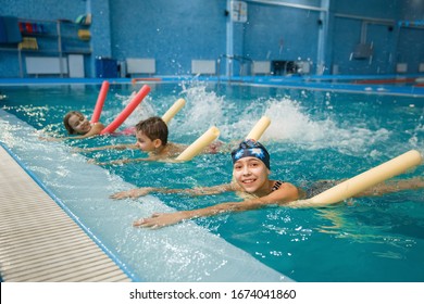 Children swimming group lies on back in the pool - Powered by Shutterstock