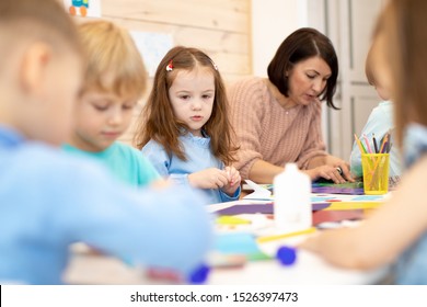 Children with teacher in class room. Group of children doing project in kindergarten. Kids hands crafting into team. - Shutterstock ID 1526397473