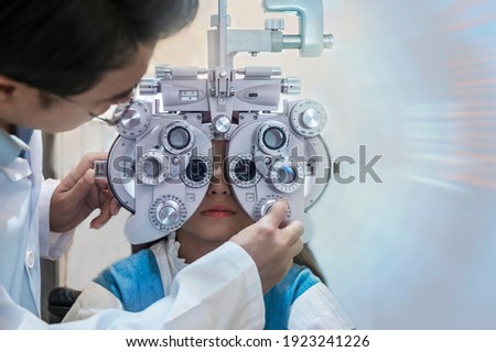 Children are tested with ophthalmology equipment by an optician. 