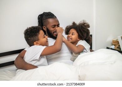 Children Touching Nose Of Hugging Dad
