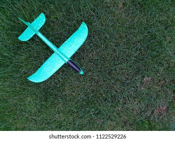 Children Toy Paraglider Airplane On Lawn, On Green Grass. Children's Toy Toy Is Made Of Polystyrene.