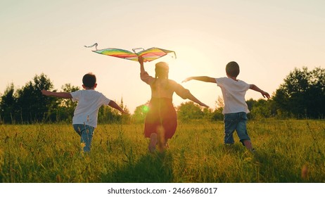 Children toy plane. Kite flies in hands of child in summer in park under sun. Children Boy, girl play with toy kite. Child's dream of flying concept, child runs across field at sunset with kite, sky