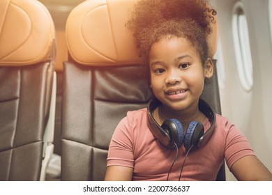 Children Traveling Alone Or Unaccompanied Minor. Child Girl Fly Travel Sitting Alone In Flight Cabin Seat Happy Smile. 