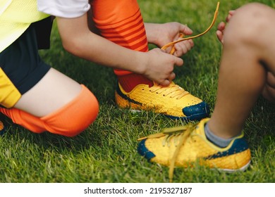 Children Tying Shoe Laces. Kids In Sports Football Team Tying Soccer Cleats. School Boys On Grass Sports Field