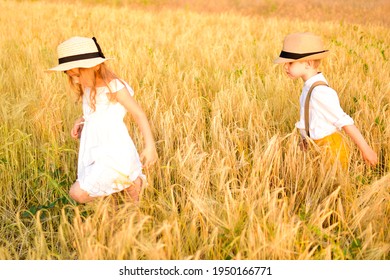 Children walk in the wheat field and play in the fresh air. Boy and girl run around the field with pleasure after quarantine and a long stay at home. Lockdown canceled. Friends are happy in freedom. 