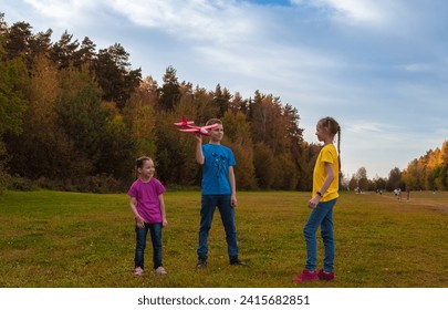 Children are walking in the park. Children play together with a toy plane. - Powered by Shutterstock