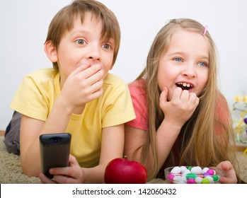 Children watching TV holding control