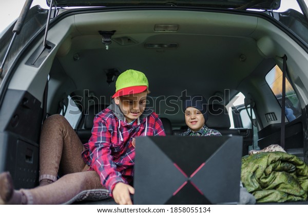 children watching\
a video on a laptop inside\
car