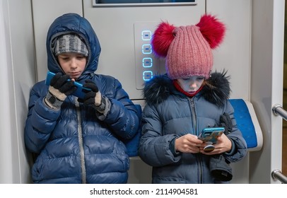 Children Are Watching Videos, Using Mobile Applications In Mobile Phones On City Underground Train. Internet Technology For Streaming Video On Mobile Phone In Underground Public Transportation.