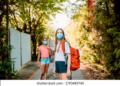 Children Wearing Face Mask Going To School. Two Teenage Girls With School Bags In Park. Education, Health Care, Pollution And Safety Concept Due To Coronavirus,pupils, Reopening And Facemask