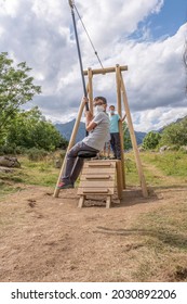 Children Wearing Masks Play On A Zip Line At A Playground In Summer Camp, Vertical