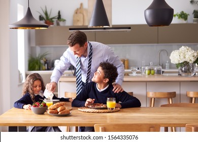 Children Wearing School Uniform Eating Breakfast As Father Gets Ready For Work - Powered by Shutterstock