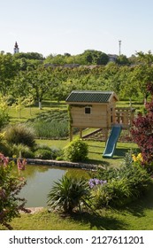 Children Wooden Playhouse In The Beautiful Garden Near The Lake