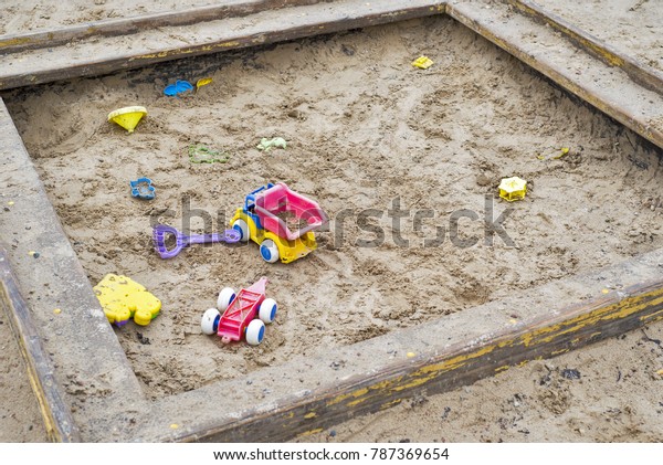 Children wooden\
sand box with some plastic\
toys