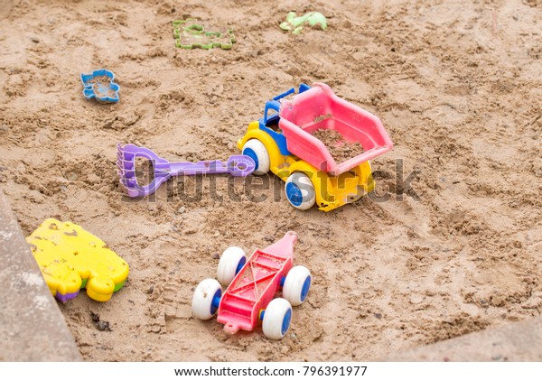 Children wooden\
sand box with some plastic\
toys