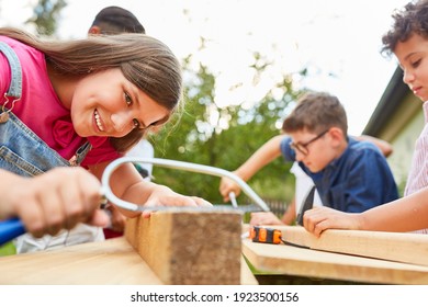Children work and do handicrafts with wood in the craftsman's workshop at the holiday camp