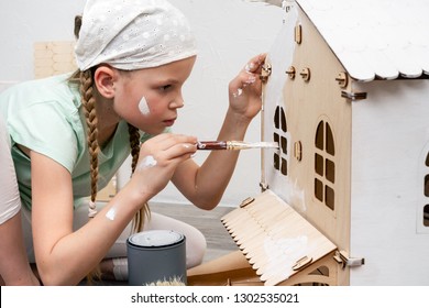 Children At Work: The Girl Neatly Paints The Facade Of The Doll House With A Small Tassel In White.