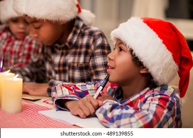 Children Writing Letter To Santa. Afro Kids Write Christmas Letter. Making A Christmas Wish List. Think About Best Presents.