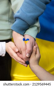 children's and adult hands together, a drawn heart in yellow and blue colors of the Ukrainian flag. Family, unity, support,. Russia's invasion of Ukraine, a request for help to the world community.
