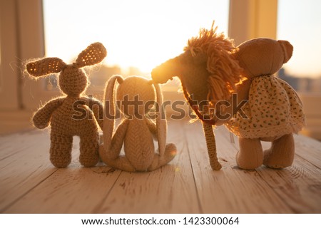 Children's animal stuffed toys bunny and teddy family on wooden floor in kids room.