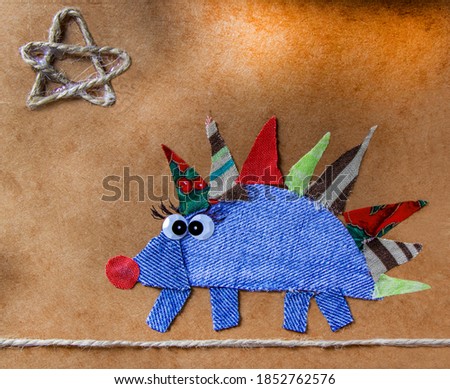 children's applique hedgehog on a paper background, applique of fabric, children's creativity,children's drawings