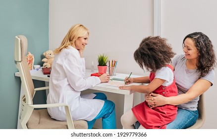 Children's Art Therapy. Beautiful Little Girl While Art Therapy With Woman Psychologist At A Medical Clinic