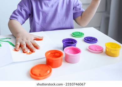 Children's art workshop, the child makes a handprint with paints. - Shutterstock ID 2310746067
