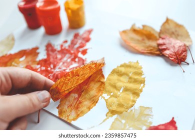 Children's autumn activity, leaf print on paper. - Powered by Shutterstock