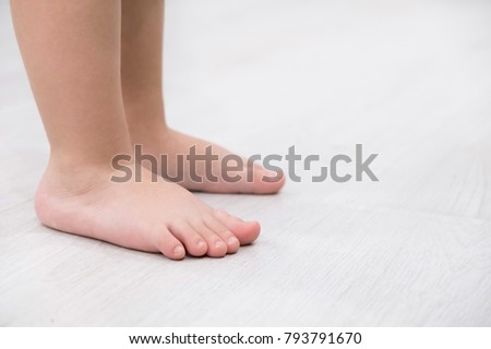 Children's bare feet. Child's bare feet on the wooden floor