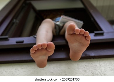 Children's Bare Legs Of A Child Sitting In The Window