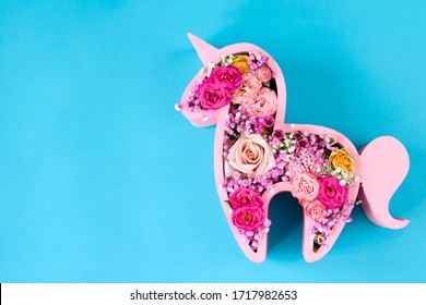 Children's Bouquet In The Form Of A Unicorn On A Blue Background. Creative Floristry. Flowers In Soft Pink Colors. The Picture In The Style Of Minimalism. 