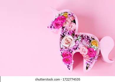 Children's Bouquet In The Form Of A Unicorn On A Pink Background. Creative Floristry. Flowers In Soft Pink Colors. The Picture In The Style Of Minimalism. 