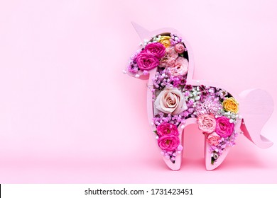 Children's Bouquet In The Form Of A Unicorn On A Pink Background. Creative Floristry. Flowers In Soft Pink Colors. The Picture In The Style Of Minimalism. 